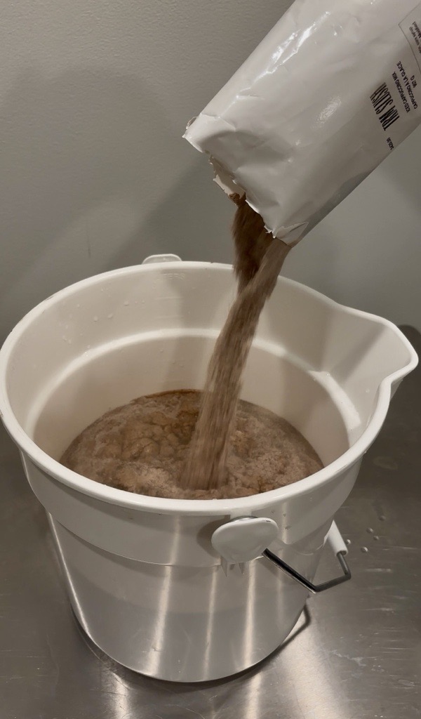 Iced Capp powder mix being poured into a bucket with water