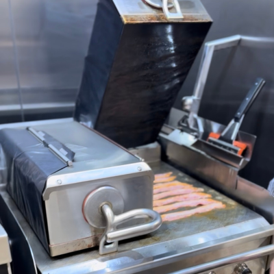 Bacon cooking on one platen on a Taylor two-sided grukk